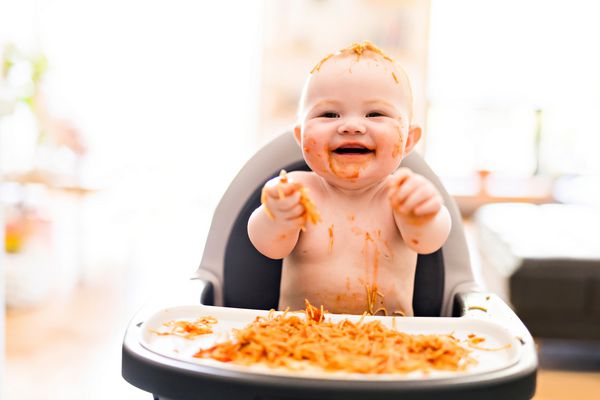 دختر بچه کوچولو که شام ​​اسپاگتی را می خورد و آشفتگی می کند