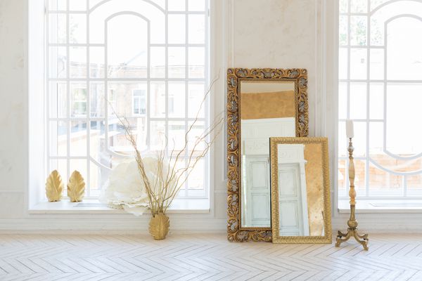 فضای داخلی لوکس اتاق نشیمن با دیوار طلایی و مبلمان شیک و گران قیمت در رنگهای سفید و طلایی