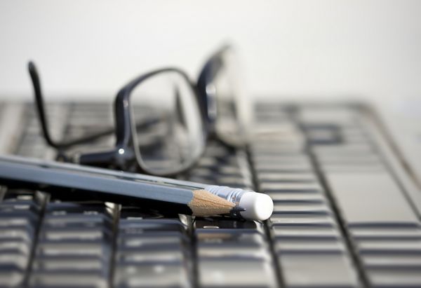 صفحه کلید لپ تاپ و مداد و عینک