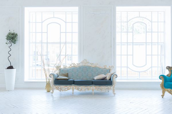 فضای داخلی لوکس اتاق نشیمن با دیوار طلایی و مبلمان شیک و گران قیمت در رنگهای سفید و طلایی