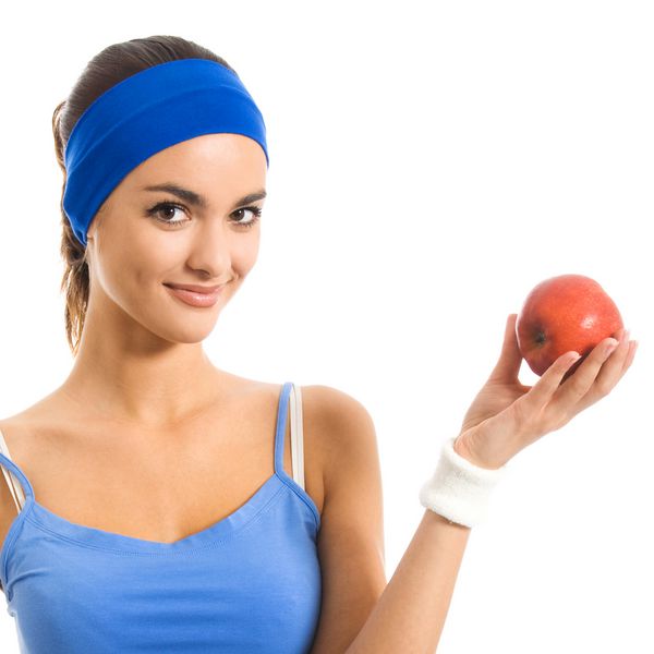 زن جوان شاد در لباس ورزشی با سیب جدا از پس زمینه سفید