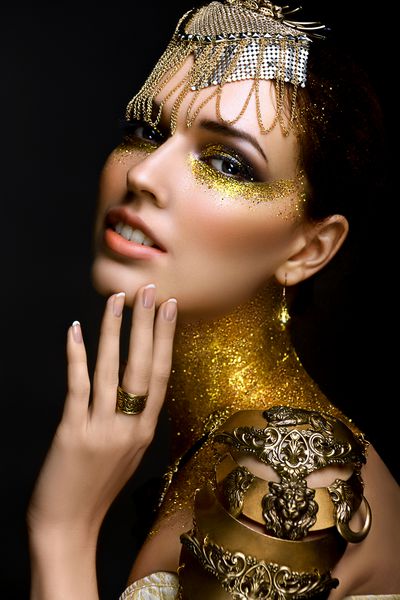 پرتره زن زیبا با جرقه های طلایی روی صورتش دختری با آرایش هنری با جرقه های طلایی مدل مد با آرایش طلایی