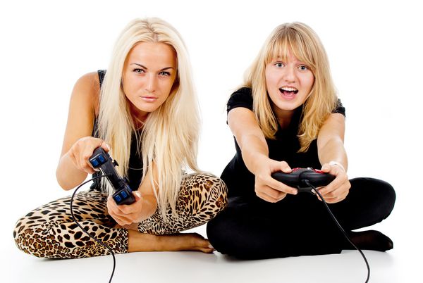 دو دختر بازی های ویدئویی ایزوله شده در زمینه سفید را انجام می دهند