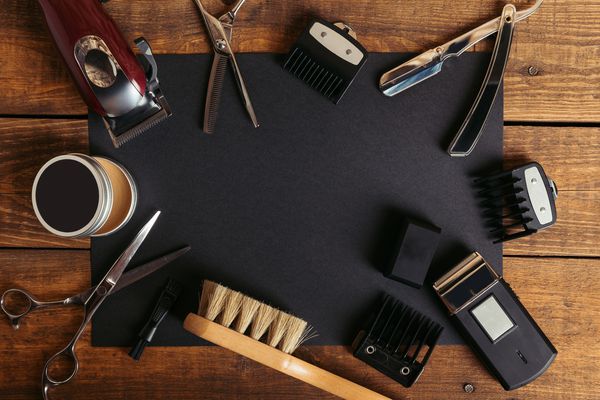 نمای برتر انواع ابزار آرایشگری حرفه ای روی کارت سیاه روی سطح چوبی