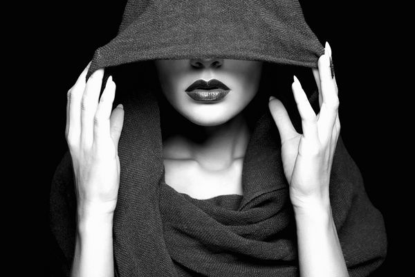 زن زیبا صورت خود را زیر کاپوت می پوشاند بخشی از صورت زنانه پرتره سیاه و سفید