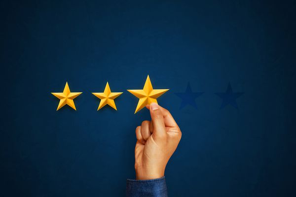 دست مشتری با دادن سه ستاره امتیاز رتبه بندی خدمات مفهوم رضایت