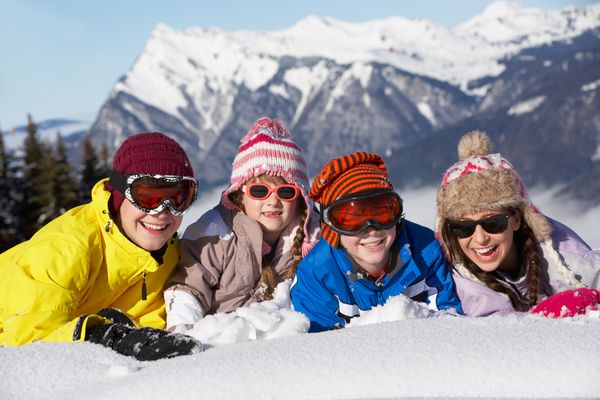 گروهی از کودکان که از تعطیلات اسکی در کوهستان سرگرم می شوند