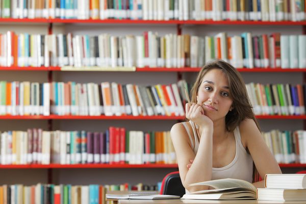 پرتره یک دانشجوی جوان در یک کتابخانه