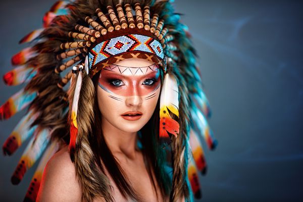 زن جوان و زیبا با زمینه بزرگ پرهای هندی آمریکایی