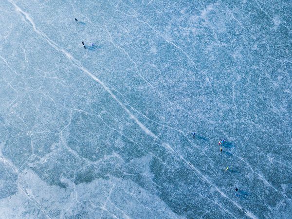 نمای هوایی دریاچه یخ زده بسیاری از اسکیت بازان یخی روی یخ مفهوم پس زمینه زمستانی سد سسکه اودولی در نزدیکی پیلسن جمهوری چک اتحادیه اروپا