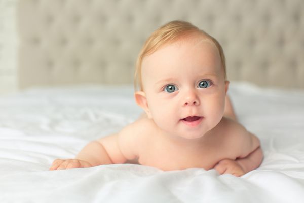 کودک کوچولو دوست داشتنی naket که روی جلد سفید پوشیده شده است