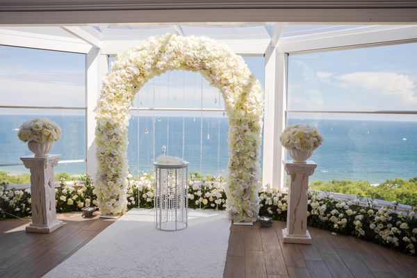 تزیینات مراسم عروسی سفید در محیط داخلی قوس عروسی سفید با گل و فرش سفید روی زمین