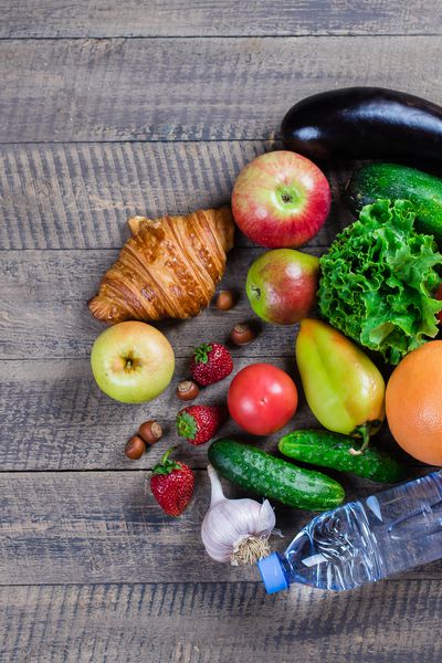 زمینه غذایی میوه ها سبزیجات غذاهای سالم بطری با آب روی یک میز سفید نمای بالا دراز کشیدن فضا را کپی کنید