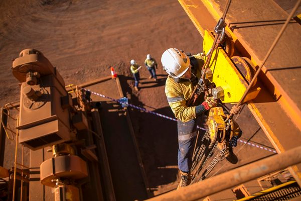 کارگر دسترسی طناب که دارای کلاه سخت افزاری است که در ارتفاع صعودی از طناب انجام نصب نصب بلوک زنجیره بلند کردن در سایت ساخت و ساز ساختمان چرخ دستی برقی پرت پرت استرالیا