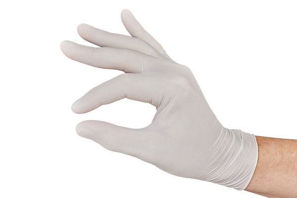 دستکش نر در دستکش پزشکی سفید وانمود می کند که داروهای جدا شده بر روی زمینه سفید را نگه می دارد
