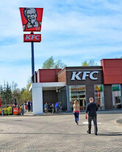افرادی که به رستوران KFC می روند زنجیره رستوران فست فود در جاده های اروپا نشان قرمز و آرم KFC لهستان ورشو 15 آوریل 2018
