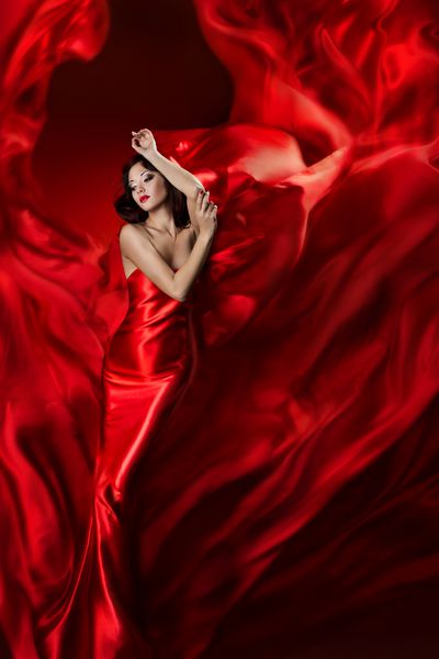 زن در لباس لباس قرمز با پارچه موج دار مفهوم رویاهای فانتزی دخترانه