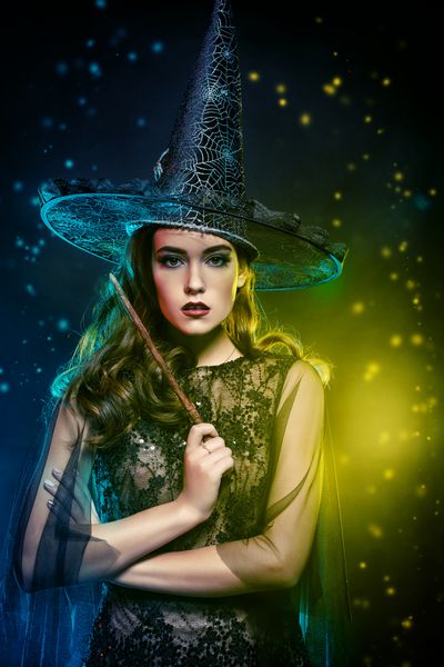 پرتره یک جادوگر زیبا در کلاه که دارای چوب جادویی است هالووین جشن