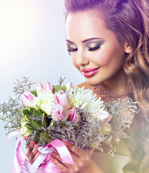پرتره دختر زیبا با گل در دست زن جوان مبارک دسته گل را نگه می دارد