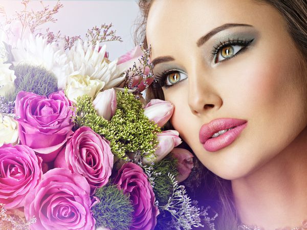 زن زیبا با دسته گلهای تازه به صورت صورت دختر زیبا با آرایش مد