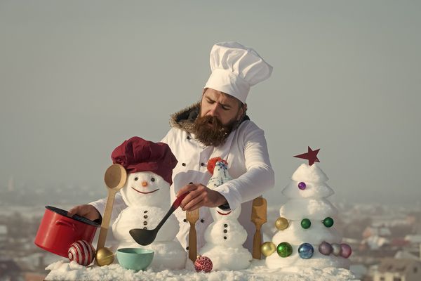 آشپز آدم برفی و درخت کریسمس برفی در آسمان آبی Hipster با ملاقه با لباس سفید مرد در روز زمستان سوپ شلوار کلاه سرآشپز کریسمس و تعطیلات سال نو غذا مفهوم آشپزی و رژیم غذایی