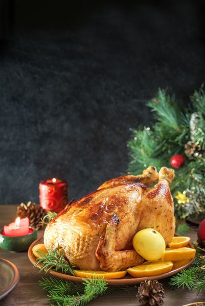 کریسمس مرغ کباب شده یا ترکیه برای شام کریسمس میز چوبی تزئین شده جشن برای شام کریسمس با مرغ پخته شده فضای کپی