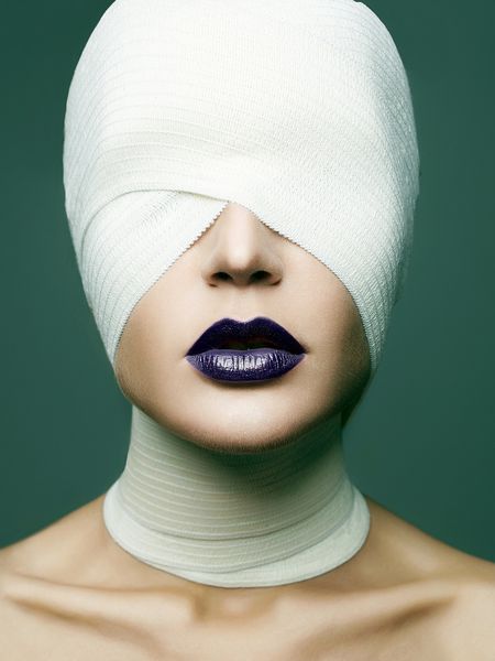 دختر در ماسک پر زرق و برق برای هالووین چهره زن پیچیده شده در بانداژ زن آرایش زیبایی رژ لب آبی جراحی پلاستیک