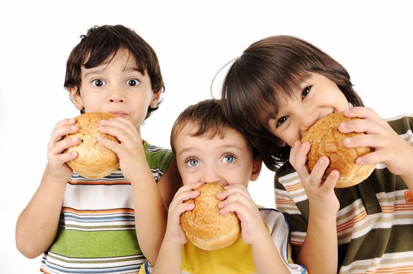 سه بچه که همبرگر می خورند