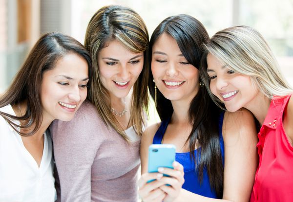 گروهی از دختران که به تلفن همراه نگاه می کنند