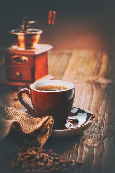 قهوه فنجان اسپرسو و چرخ قهوه عطر بو داده لوبیای قهوه روی میز چوبی طراحی هنری