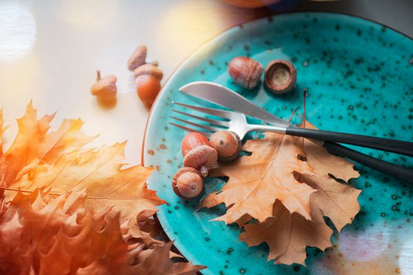 شام مراسم شکرگزاری میز چوبی شکرگذاری که با برگهای بلوط و بلوط پاییزی روشن تزئین شده است تنظیم جدول تعطیلات طراحی هنری