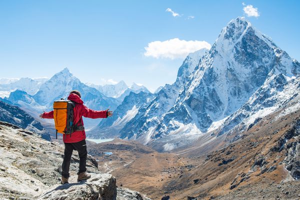 Trekker در حاشیه صخره کوه ایستاده و به دنبال منظره زیبای MtAma Dablam 6812 متر و Cholatse 6440 متر در مسیر چو لا پاس نپال است