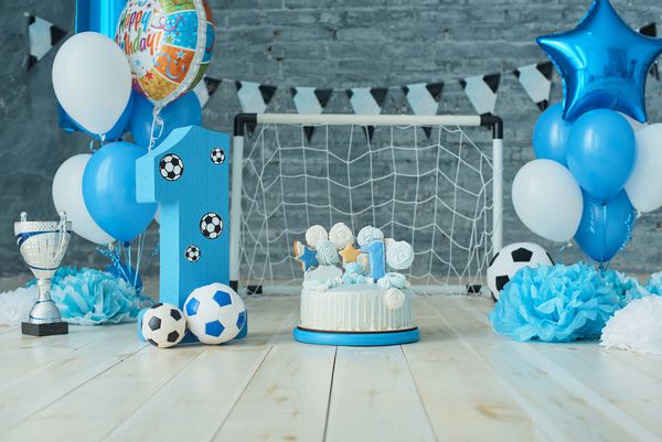 دکوراسیون پس زمینه جشن برای تولد با کیک حروف گفته شده یک و بالن آبی در استودیو Boy Boy Cake Smash مفهوم سال اول تبریکات تولد موضوع فوتبال