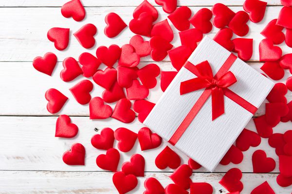 قلب قرمز و جعبه هدیه در زمینه چوبی سفید نمای بالا کپی رایت