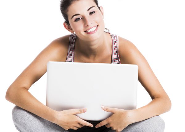 دانشجویی زیبا که با یک لپ تاپ در طبقه و در طبقه نشسته نشسته بر روی یک زمینه سفید جدا شده است