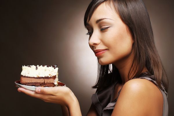 زن جوان زیبا و خندان با کیک