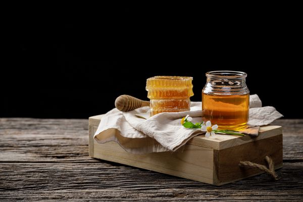 زنبور عسل در گلدان و لانه زنبوری با گلدان عسل و گل روی میز چوبی محصولات زنبور عسل با استفاده از مواد طبیعی طبیعی آلی فضای متن را کپی کنید