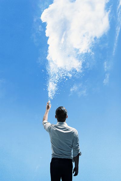 نقاشی انسان با قوطی اسپری در پس زمینه آسمان آبی