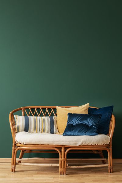 کاناپه روتان با بالش در فضای داخلی اتاق نشیمن زیبا با فضای کپی بر روی دیوار سبز خالی