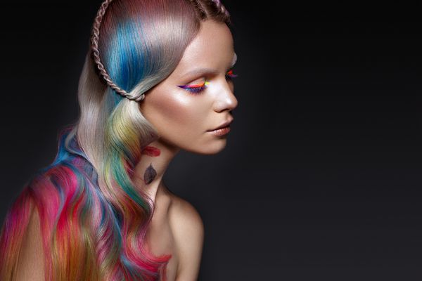 دختر زیبا با موهای چند رنگ و آرایش خلاق و مدل مو صورت زیبایی عکس گرفته شده در استودیو