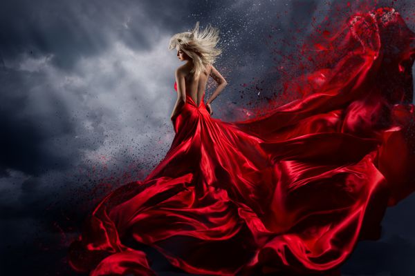 زن با لباس قرمز بر فراز آسمان طوفان لباس پارچه ای که در حال پرواز است به عنوان چلپ چلوپ پرواز می کند