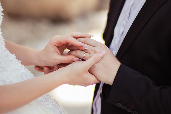 عروس و داماد حلقه های عروسی را بپوشید انگشت کوچک خود را به یکدیگر وصل کنید