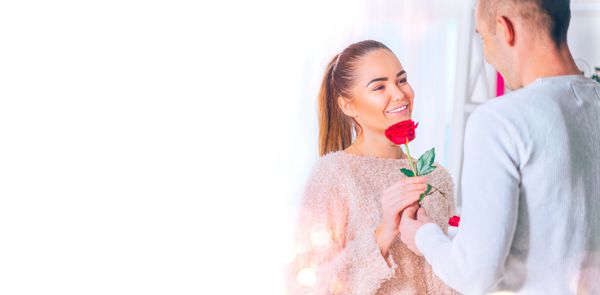 هدیه روز ولنتاین مرد جوان خوش تیپ گل گل رز قرمز را به دوست دختر خود هدیه می دهد برگزاری زن و شوهر جوان برخاست و لبخند زد روز ولنتاین و روز x27؛ عشق عشق دست در دست عاشقانه مفهوم دوستیابی