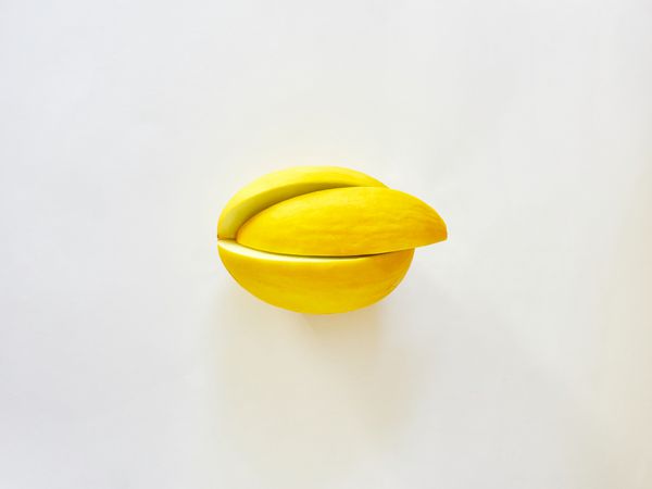 میوه خربزه زرد جدا شده در پس زمینه سفید که از بالا مشاهده می شود نگاه فلات مفهوم مینیمالیسم تصویر