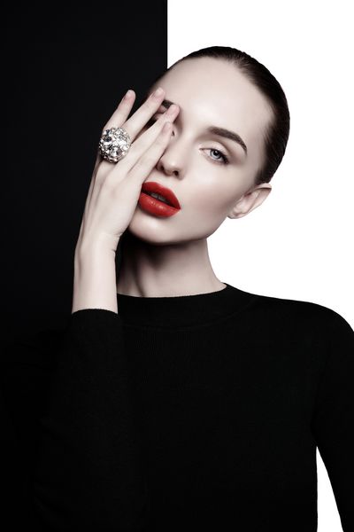 خانم جوان با انگشتر بزرگ با الماس در استودیوی سیاه و سفید زن زیبا با لب های کامل و رژ لب قرمز در فتوشیمیایی پرتره مد مدل شیک