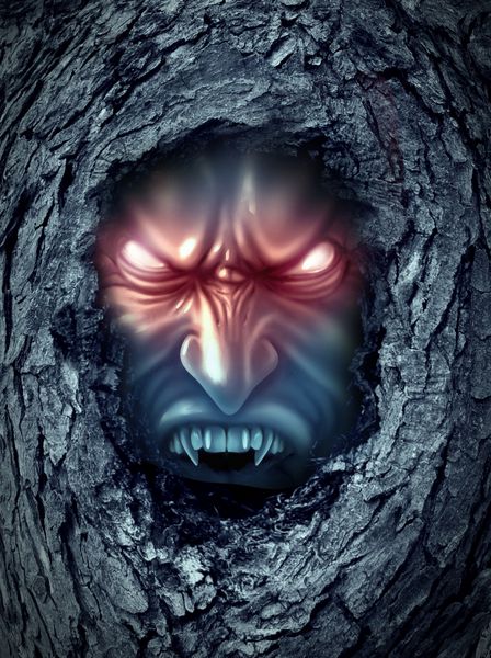 شبح زامبی خون آشام و چشم های شرور درخشان که در داخل یک تنه درخت خالی از سکنه قدیمی زندگی می کنند به عنوان نمادی از هالووین ارواح وحشت بد که دنیای زنده را به عنوان یک دیو هیولا به دنبال خون می گشود