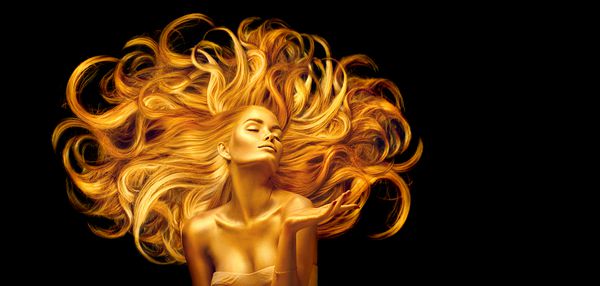 زن طلایی مدل لباس مجلسی زیبایی با آرایش طلایی و موهای بلند اشاره ای روی زمینه سیاه درخشش پوست و موهای زائد فلزی نگاه نگاه پرتره هنری مد مدل مو