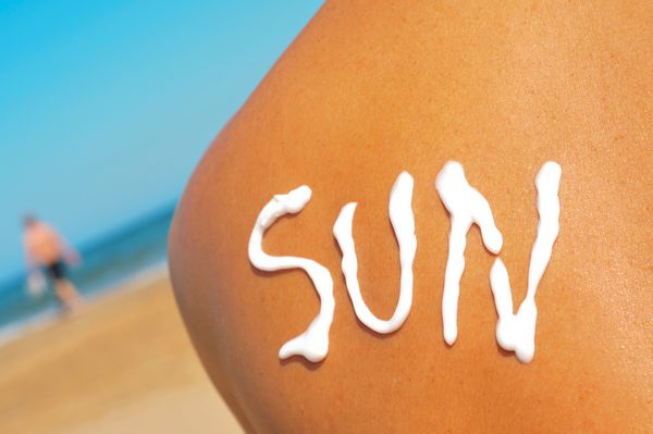 کلمه خورشید که با آفتاب بسته شده بر روی پشت مردی که در حال آفتاب گرفتن در ساحل است نوشته شده است
