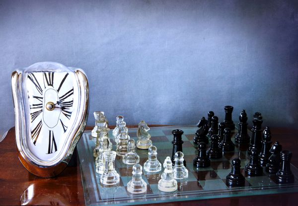 یک ساعت ذوب و تحریف شده دالی و یک تخته شطرنج با یک بازی در حال انجام است