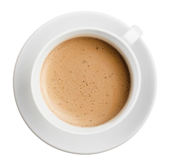 فنجان قهوه با فوم جدا شده در رنگ سفید همه در فوکوس نمای بالا